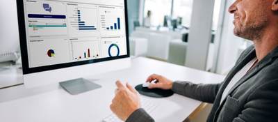 man at computer with data on screen